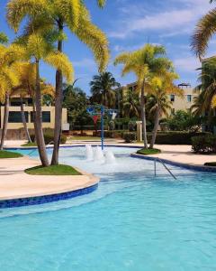 een zwembad met palmbomen in een resort bij Aquatika Paraíso Tropical in Loiza