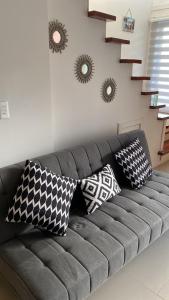 un sofá con almohadas en la sala de estar en Departamento manantiales, en Punta Arenas