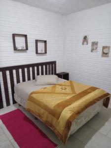 - une chambre avec un grand lit et une tête de lit en bois dans l'établissement Hospedaria Mirante da maré ap4, à Imbituba
