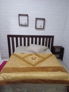 - un lit dans une chambre avec 2 photos sur le mur dans l'établissement Hospedaria Mirante da maré ap4, à Imbituba