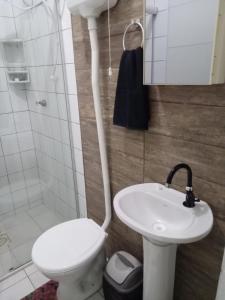 La salle de bains est pourvue de toilettes et d'un lavabo. dans l'établissement Hospedaria Mirante da maré ap4, à Imbituba