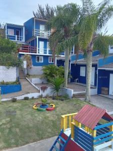 une maison avec une aire de jeux en face dans l'établissement Hospedaria Mirante da maré ap4, à Imbituba