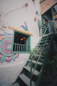 a stair case in front of a building with a mural at Hostal Casa del Frailejón - Café in Monguí
