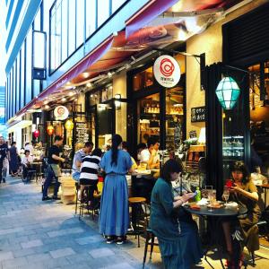 a group of people sitting at tables outside a restaurant at Minamide Building 2-4F / Vacation STAY 6127 in Osaka