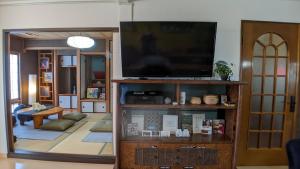 sala de estar con TV de pantalla plana en un centro de entretenimiento en Minamide Building 2-4F / Vacation STAY 6127, en Osaka