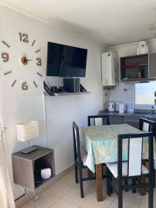 a kitchen with a table and a clock on the wall at C & N - Altos de la Bahía in El Calafate