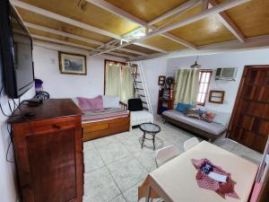 a living room with a tv and a couch at Casa da Dinda à 650m da praia de Itaúna in Saquarema
