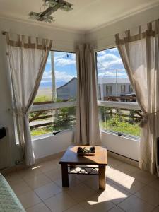 a room with a table and two large windows at C & N - Altos de la Bahía in El Calafate