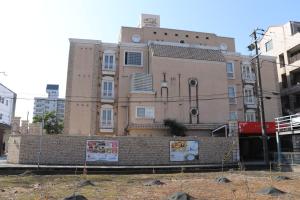 un gran edificio de ladrillo con un reloj encima en ホテルシエル, en Himeji