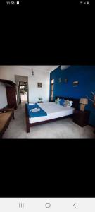 sypialnia z dużym łóżkiem i niebieskimi ścianami w obiekcie Chillax Villa w mieście Hikkaduwa