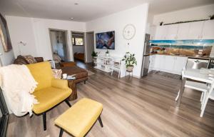 een woonkamer met een bank en een tafel en een keuken bij Bush to Beach Getaway in Port Sorell