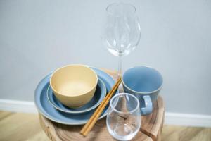 een houten tafel met eetstokjes en kopjes en een wijnglas bij リアル錦糸101 in Tokyo