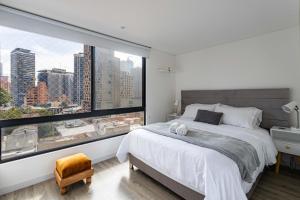 1 dormitorio con ventana grande y cama grande en Loft nuevo, moderno, central, en Bogotá