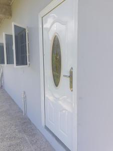 a white door with a round window on it at Rooftop Inn Apartments in Piarco
