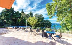un patio con mesas y sillas y vistas al agua en Amazing Home In Klenovica With House Sea View, en Klenovica