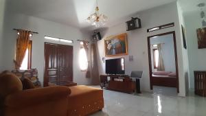 a living room with a couch and a television at Vila Dinar Garden View in Lembang