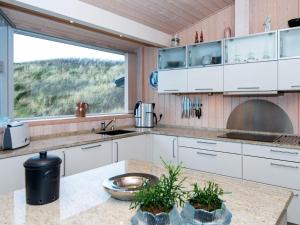 eine Küche mit weißen Schränken und einem großen Fenster in der Unterkunft Holiday home Henne CXXXV in Henne Strand