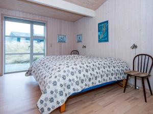 Schlafzimmer mit einem Bett, einem Tisch und einem Fenster in der Unterkunft Holiday home Henne CXXXV in Henne Strand
