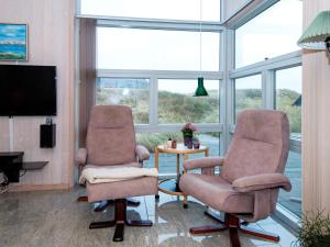 2 Stühle und ein Tisch in einem Zimmer mit Fenstern in der Unterkunft Holiday home Henne CXXXV in Henne Strand