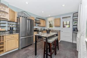 a kitchen with a stainless steel refrigerator and a table at Cozy & Inviting Townhome in Frederick