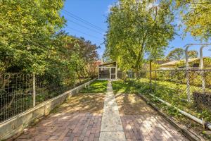 a walkway in a park with trees and a fence at Cozy & Inviting Townhome in Frederick