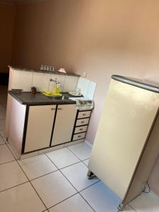 a small kitchen with a sink and a refrigerator at Kitnet ao lado do centro in Itabira