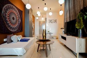 ein Wohnzimmer mit einem Bett, einem TV und einem Tisch in der Unterkunft ITCC Manhattan Suites by Pinstay Premium in Donggongon