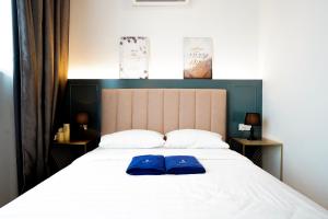 un letto con due cuscini blu sopra di ITCC Manhattan Suites by Pinstay Premium a Donggongon