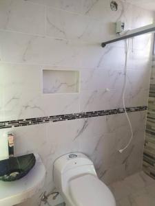 Baño blanco con aseo y lavamanos en 4 Cuarto independiente con sala en Ambato, en Ambato