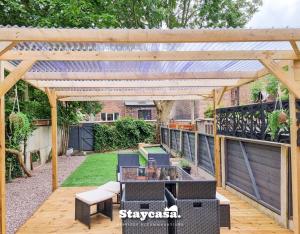 une pergola en bois avec une table et des chaises sur une terrasse dans l'établissement Spacious 5br Home In Leafy Withington, à Manchester