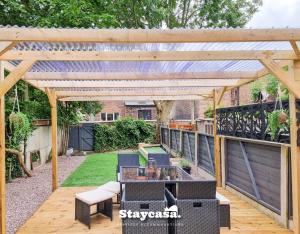 a wooden pergola with a table and chairs on a patio at Spacious 5br Home In Prime Manchester Location in Manchester