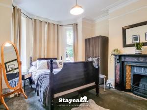 sypialnia z łóżkiem i kominkiem w obiekcie Spacious 5br Home In Prime Manchester Location w Manchesterze
