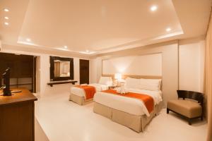 ein Hotelzimmer mit 2 Betten und einem TV in der Unterkunft White House Beach Resort in Boracay