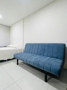 um banco azul num quarto ao lado de uma cama em Sirari Palm Monoambiente Premium !!! em Santa Cruz de la Sierra