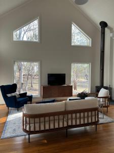 ein Wohnzimmer mit einem Sofa und einem TV in der Unterkunft Summit House Armidale - 2 or 4 Bedrooms in Armidale