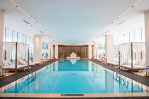 a large swimming pool with chairs in a building at Sanya Haitang Bay Moutai Resort Superior Hotel in Sanya