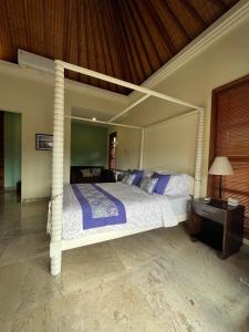 a bedroom with a white bed with a canopy at Villa Gekyu in Jimbaran