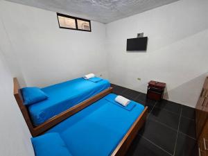 a room with two beds and a television in it at Departamento de Jules in Puerto Ayora