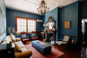 una sala de estar con paredes azules y una lámpara de araña. en The Bronte Boutique Hotel, en Morpeth