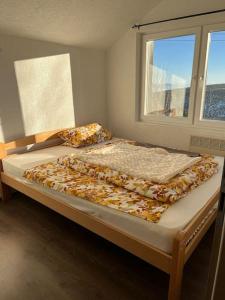 a large bed in a room with a window at Winterheim Sonnenberg in Tetovo