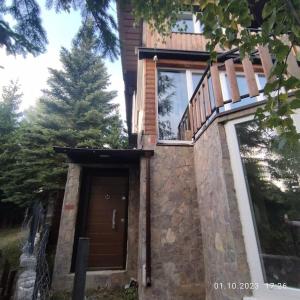 a house with a wooden door and a balcony at Winterheim Sonnenberg in Tetovo