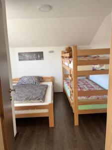 a small room with two bunk beds and a door at Winterheim Sonnenberg in Tetovo
