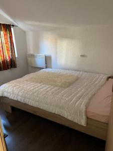 a bedroom with a bed with a white bedspread at Winterheim Sonnenberg in Tetovo