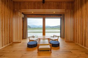 UsaGLOCE宇佐 田宮-田んぼのお城- l 美しい田園と山々を一望 癒しと伝統を体感的一间有桌子、椅子和大窗户的房间