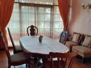 uma sala de jantar com uma mesa e cadeiras e uma janela em Vila Dinar Tulip Hill em Lembang