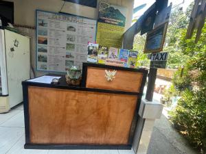 recepción de un restaurante con puerta de madera en Ayu Homestay, en Ubud