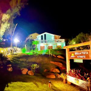 una casa sentada en la cima de una colina por la noche en Bella Vista Kitnets en Farol de Santa Marta
