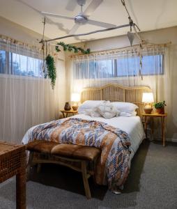 a bedroom with a large bed with a large window at Beachside Bellingen in Urunga