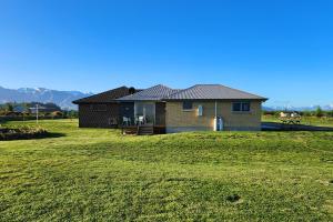 a house on a grassy field with a house at Glen View Escape in Twizel