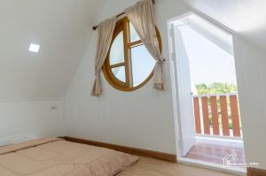 małą sypialnię z oknem i łóżkiem w obiekcie นอร์ดิกเฮ้าส์ แอนด์ คอฟฟี่หนองบัวลำภู w mieście Ban Huai Luk